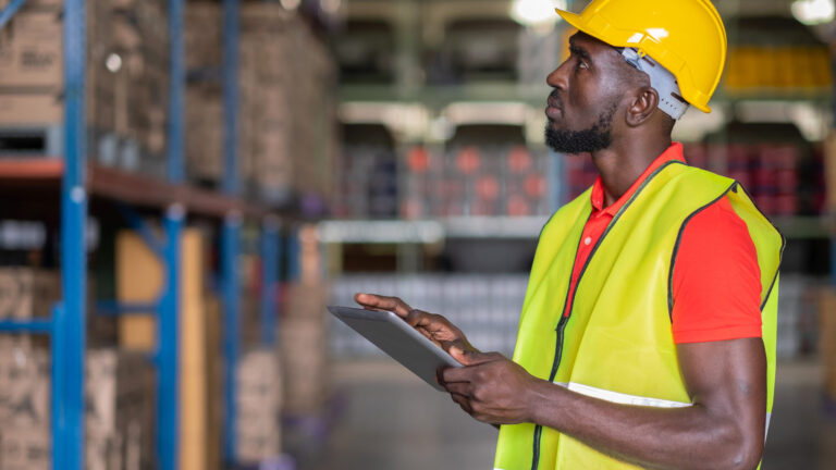 Employé homme en tenue de sécurité en train de faire l'inventaire des stocks