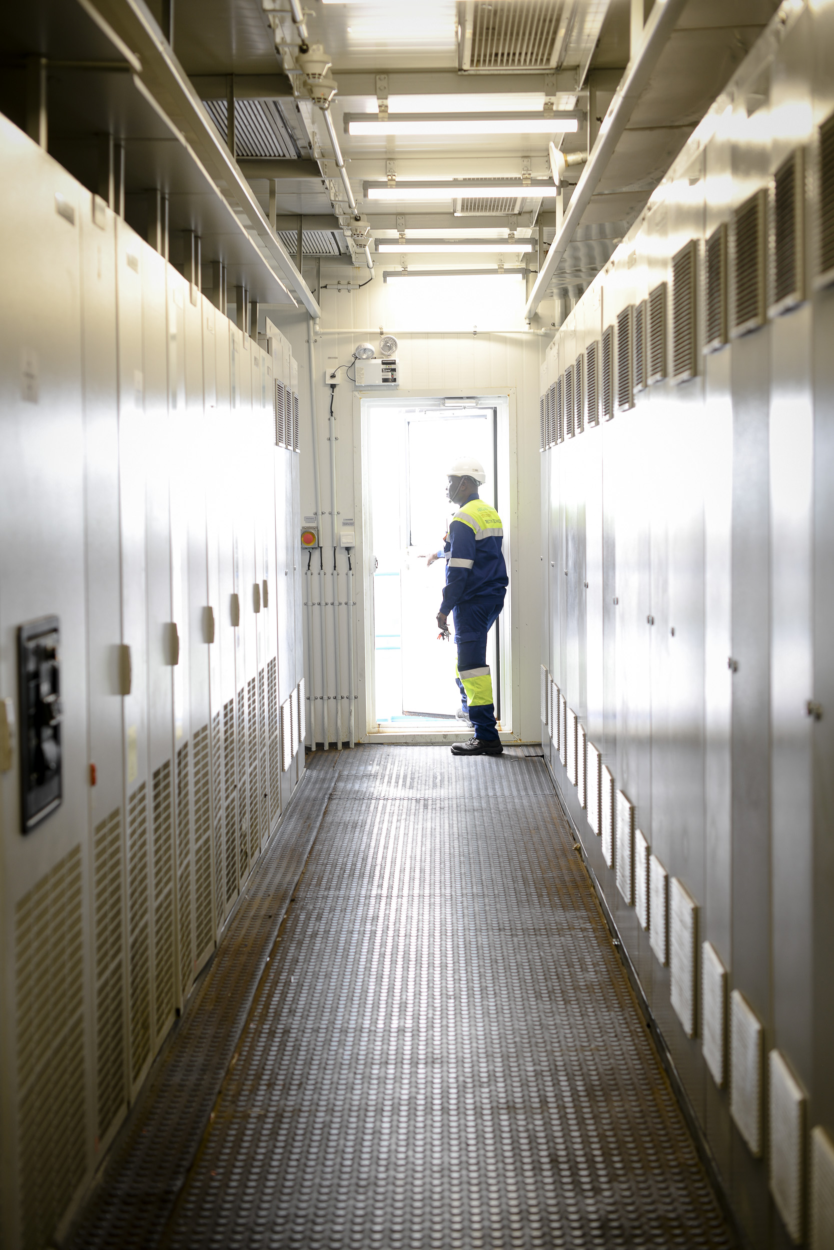 employé maritime dans une coursive ouvrant la porte vers l'extérieur