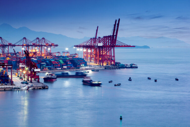 port de fret maritime avec grue au second plan et bateau en attente