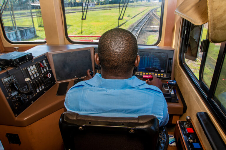 Conducteur de train en Afrique dans sa cabine, en train de piloter une locomotive