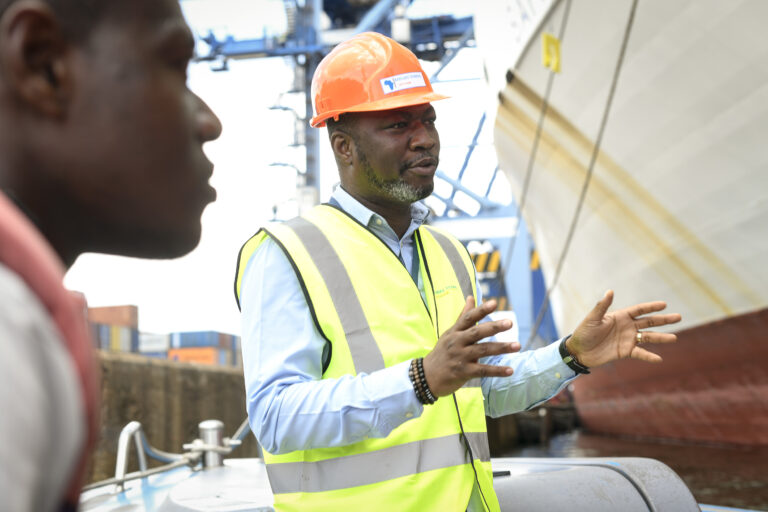 Employé portuaire donnant des consignes à ses collaborateurs dans un terminal