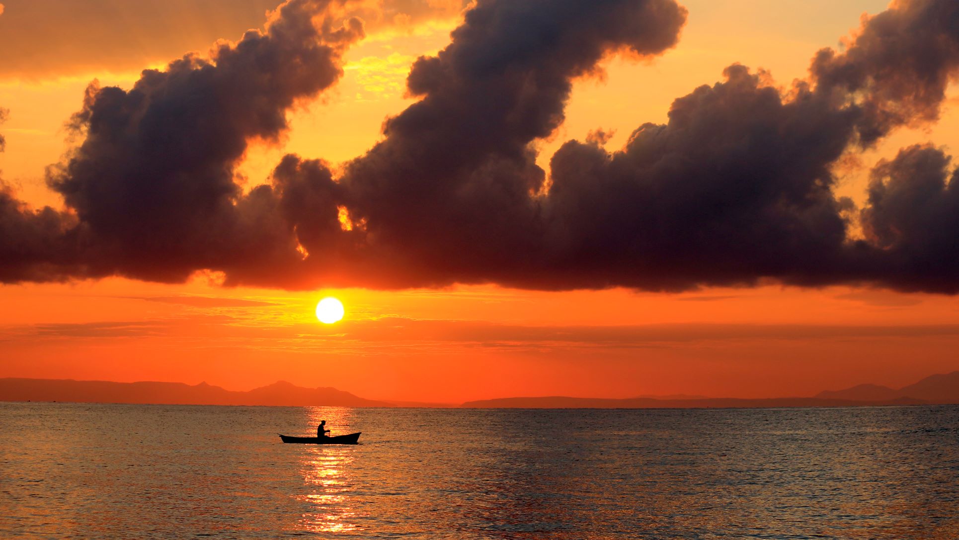 Homme sur sa pirogue au couché de soleil au Malawi