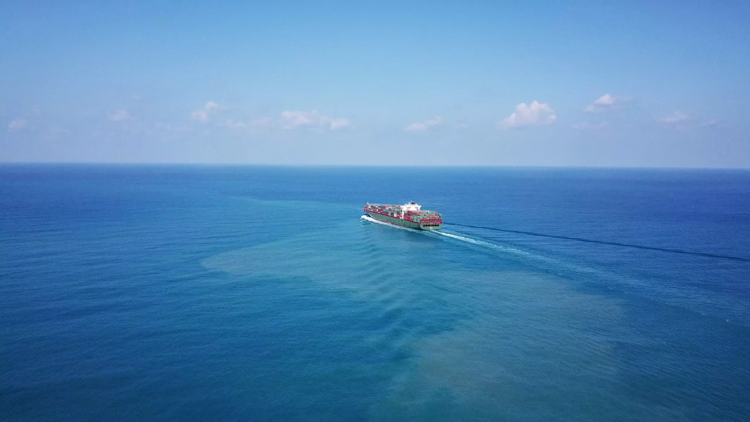 Bateau porte conteneurs chargé en train de naviguer sur l'océan