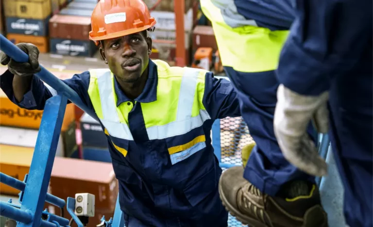 Deux employés portuaires en train d'échanger sur une passerelle au terminal d'Abidjan